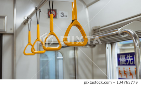 Straps lined up inside the train, and interior facilities near priority seats Straps lined up inside the train, and interior facilities near priority seats 134765779