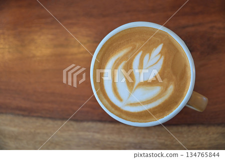 Top view of latte art coffee on wooden table for drinking in morning Top view of latte art coffee on wooden table for drinking in morning 134765844