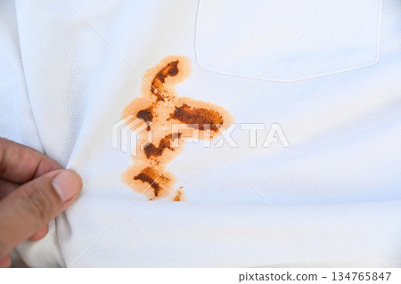 hand showing dirty sauce food stain on white shirt from eating in daily life 134765847