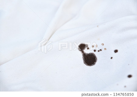 dirty black sauce stain on white shirt in daily life. stain for cleaning concept. dirty black sauce stain on white shirt in daily life. stain for cleaning concept. 134765850