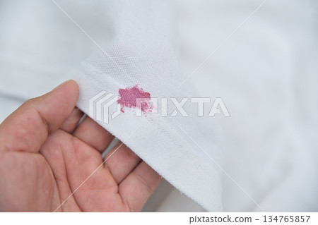 dirty pink cosmetic stain on white shirt in daily life. stain for cleaning concept. 134765857