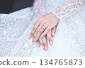 hands of bride wearing wedding ring in ring finger for Valentine's day concept 134765873