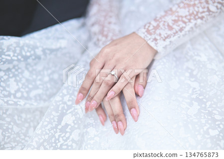 hands of bride wearing wedding ring in ring finger for Valentine's day concept hands of bride wearing wedding ring in ring finger for Valentine's day concept 134765873