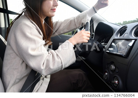 Young Asian woman checking the dashcam in her car Young Asian woman checking the dashcam in her car 134766004