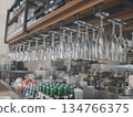 Wine glasses hanging from the ceiling and a counter - a restaurant interior 134766375