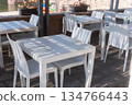 Minimal outdoor cafe setup with clean white tables and simple modern design. Soft daylight creates a bright and airy atmosphere, ideal for lifestyle, hospitality and food-related visuals 134766443