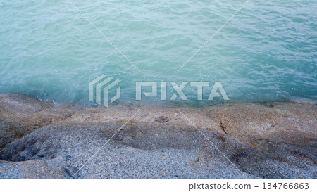 Top View of Granite Stone Coastline Meeting the Blue Sea Top View of Granite Stone Coastline Meeting the Blue Sea 134766863