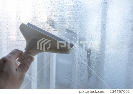 一名工人正在使用除露刮水器清除水滴。 134767001