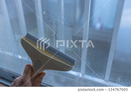 A worker using a dew eliminator wiper to remove water droplets 134767005