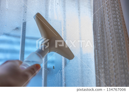 A worker using a dew eliminator wiper to remove water droplets A worker using a dew eliminator wiper to remove water droplets 134767006