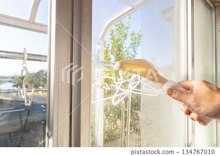 一名工人正在使用除露刮水器清除水滴。 134767010