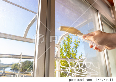 一名工人正在使用除露刮水器清除水滴。 134767011