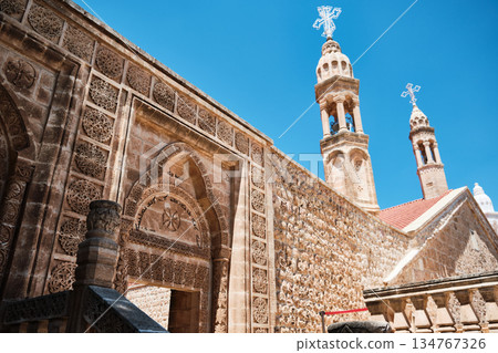 Historic Stone Church with Twin Bell Towers Under Blue Sky 134767326
