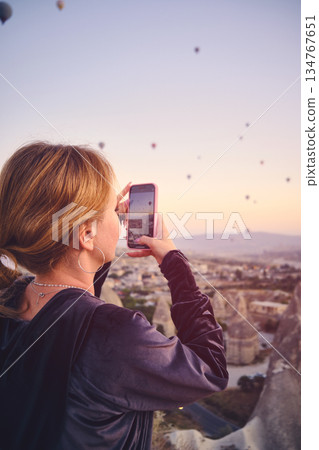 Traveler Photographing Hot Air Balloons at Sunrise 134767651