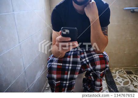 Man Using Smartphone in Bathroom 134767652