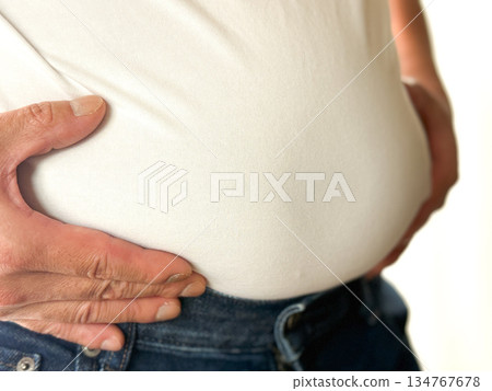 中年男子一手扶著啤酒肚 134767678