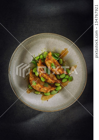 Gourmet Asian Dumplings with Edamame and Sesame Sauce on Dark Background Gourmet Asian Dumplings with Edamame and Sesame Sauce on Dark Background 134767921