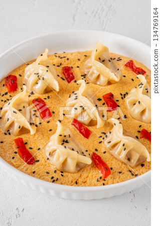 Steamed gyoza dumplings in creamy Tom Yum sauce with sesame garnish Steamed gyoza dumplings in creamy Tom Yum sauce with sesame garnish 134769164