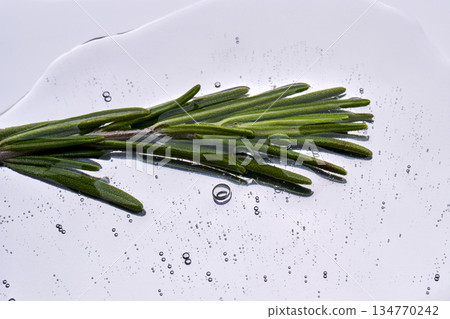 Rosemary sprig immersing in transparent cosmetic serum Rosemary sprig immersing in transparent cosmetic serum 134770242