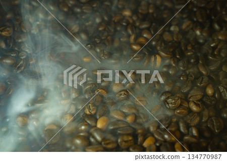 Close-up of roasted coffee beans with soft steam and haze, dramatic warm lighting, rich texture background for cafe and gourmet themes Close-up of roasted coffee beans with soft steam and haze, dramatic warm lighting, rich texture background for cafe and gourmet themes 134770987