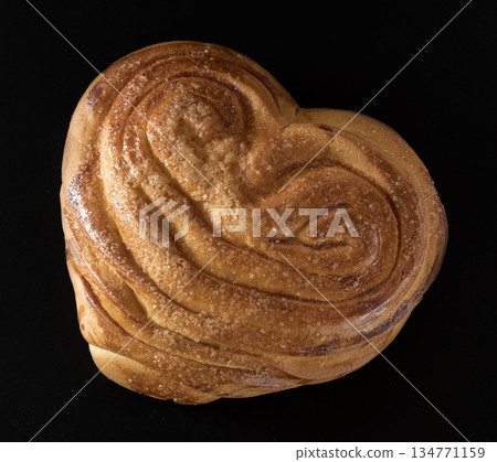Sweet ruddy freshly baked bun on black background Sweet ruddy freshly baked bun on black background 134771159