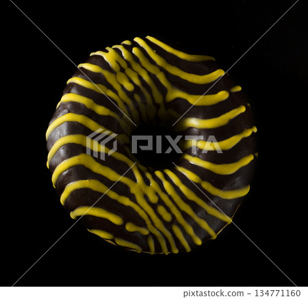 American donut covered with chocolate on black background 134771160