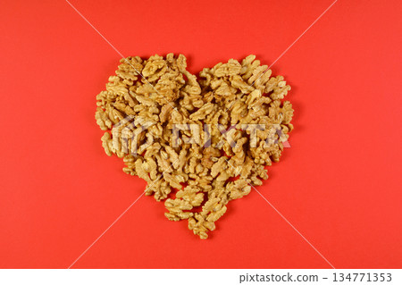 walnut in the shape of a heart on a red background. walnut in the shape of a heart on a red background. 134771353