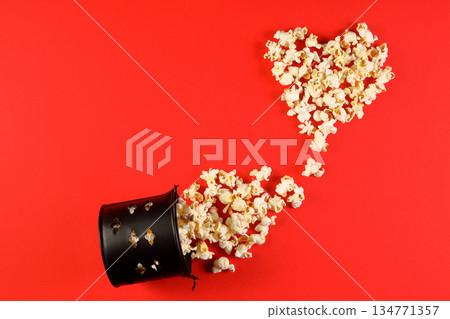 Love cinema concept of popcorn. Heart shaped white fluffy popcorn on red background with empty space for text. Valentine days Love cinema concept of popcorn. Heart shaped white fluffy popcorn on red background with empty space for text. Valentine days 134771357