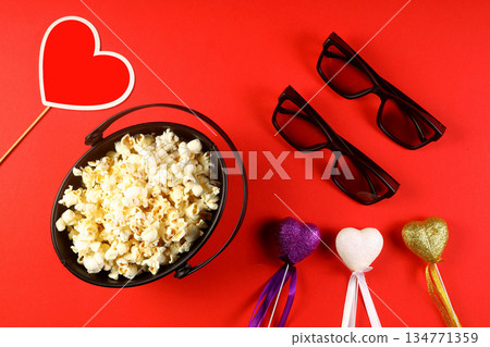 Love cinema concept of popcorn. Heart shaped white fluffy popcorn on red background with empty space for text. Valentine days Love cinema concept of popcorn. Heart shaped white fluffy popcorn on red background with empty space for text. Valentine days 134771359