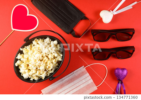 Love cinema concept of popcorn. Heart shaped white fluffy popcorn on red background with empty space for text. Valentine days Love cinema concept of popcorn. Heart shaped white fluffy popcorn on red background with empty space for text. Valentine days 134771360