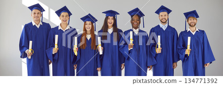 Banner with happy diverse university students with diplomas in graduation caps and gowns Banner with happy diverse university students with diplomas in graduation caps and gowns 134771392