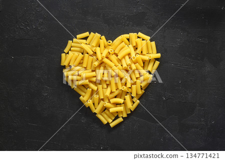 Pasta in the shape of a heart on a black background. Pasta in the shape of a heart on a black background. 134771421