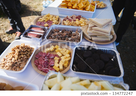 Charcuterie Outdoor Party Spread With Cheese Platter, Nuts, Cookies, And Oranges 134772247