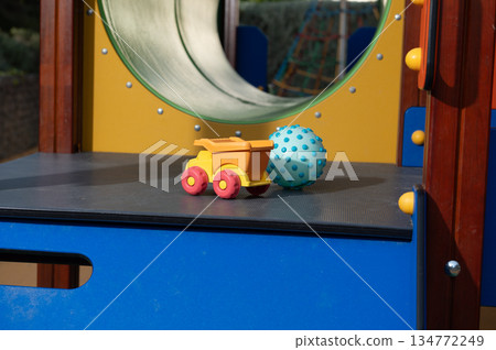 Colorful Toy Dump Truck and Spiky Ball on Playground Platform at Daytime Colorful Toy Dump Truck and Spiky Ball on Playground Platform at Daytime 134772249