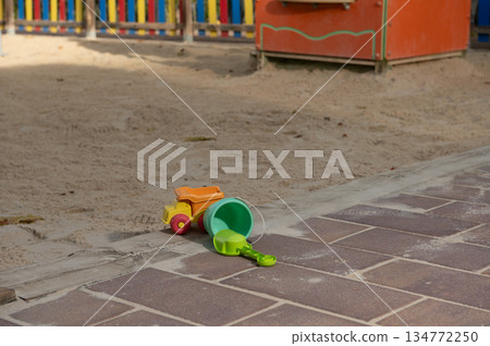 Bright Plastic Beach Toys: Green Bucket, Orange Truck And Shovel On Brick Path By Sandbox 134772250