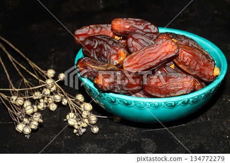 Dried dates on a wooden table in silver dishes close-up. Composition of dried dates in ramadan dish Dried dates on a wooden table in silver dishes close-up. Composition of dried dates in ramadan dish 134772279