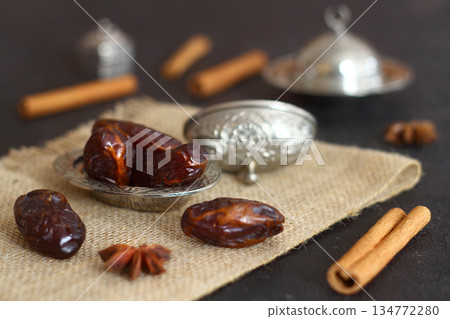 Dried dates on a wooden table in silver dishes close-up. Composition of dried dates in ramadan dish Dried dates on a wooden table in silver dishes close-up. Composition of dried dates in ramadan dish 134772280