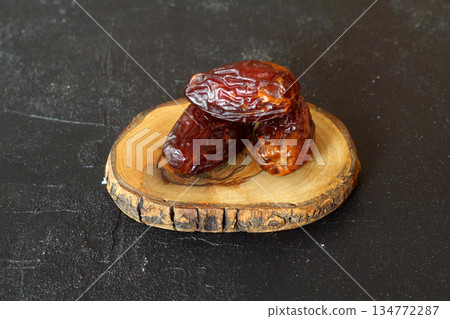 Dried dates on a wooden table in silver dishes close-up. Composition of dried dates in ramadan dish on wooden table. Dried dates on a wooden table in silver dishes close-up. Composition of dried dates in ramadan dish on wooden table. 134772287