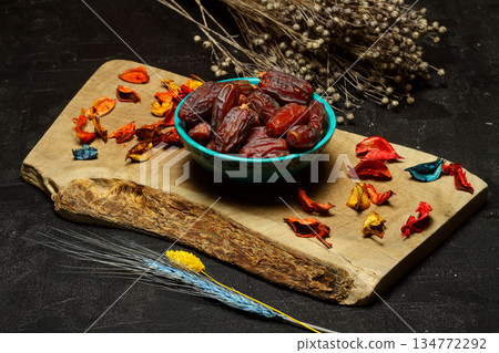 Dried dates on a wooden table in silver dishes close-up. Composition of dried dates in ramadan dish Dried dates on a wooden table in silver dishes close-up. Composition of dried dates in ramadan dish 134772292