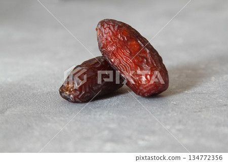 Dates on a stone background. Dried fruits. Dried dates lie next to each other Dates on a stone background. Dried fruits. Dried dates lie next to each other 134772356