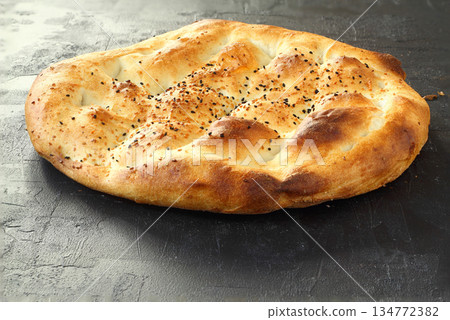 Slices of Ramadan Pita (Ramazan Pidesi) Traditional Turkish bread for holy month Ramadan on black background Slices of Ramadan Pita (Ramazan Pidesi) Traditional Turkish bread for holy month Ramadan on black background 134772382