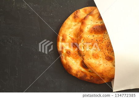 Slices of Ramadan Pita (Ramazan Pidesi) Traditional Turkish bread for holy month Ramadan on black background Slices of Ramadan Pita (Ramazan Pidesi) Traditional Turkish bread for holy month Ramadan on black background 134772385