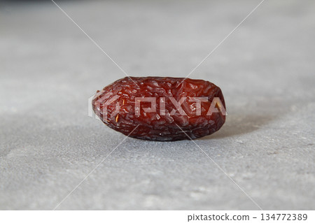 Dates on a stone background. Dried fruits. Dried dates lie next to each other 134772389
