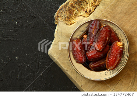 Dried dates on a wooden table in silver dishes close-up. Composition of dried dates in ramadan dish 134772407