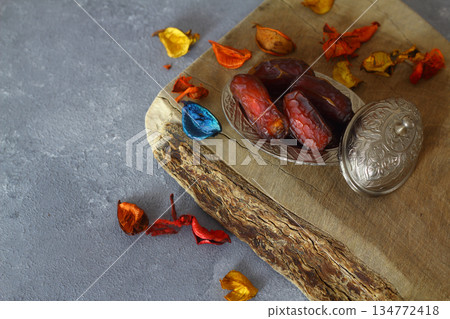 Dried dates on a wooden table in silver dishes close-up. Composition of dried dates in ramadan dish 134772418