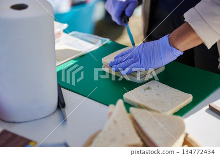 Outdoor Food Prep Gloved Hands Assemble Sandwiches On Green Work Surface 134772434