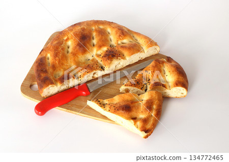 Slices of Ramadan Pita (Ramazan Pidesi) Traditional Turkish bread for holy month Ramadan on white background Slices of Ramadan Pita (Ramazan Pidesi) Traditional Turkish bread for holy month Ramadan on white background 134772465