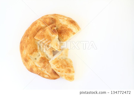 Slices of Ramadan Pita (Ramazan Pidesi) Traditional Turkish bread for holy month Ramadan on white background. 134772472