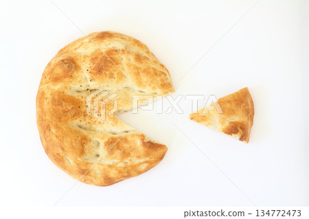 Slices of Ramadan Pita (Ramazan Pidesi) Traditional Turkish bread for holy month Ramadan on white background. Slices of Ramadan Pita (Ramazan Pidesi) Traditional Turkish bread for holy month Ramadan on white background. 134772473