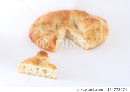 Slices of Ramadan Pita (Ramazan Pidesi) Traditional Turkish bread for holy month Ramadan on white background. Slices of Ramadan Pita (Ramazan Pidesi) Traditional Turkish bread for holy month Ramadan on white background. 134772474